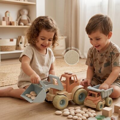 4bb4dd3b-a7e2-4dda-9a85-b392442cf70a - Da-Da Kids Two children play with pastel wooden toy trucks and pebbles on a wooden floor; a circular label reads Materiales Bioplásticos in the scene.